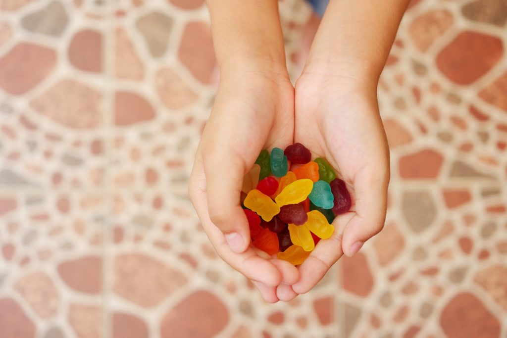Child's hand holding colourful gummy jelly